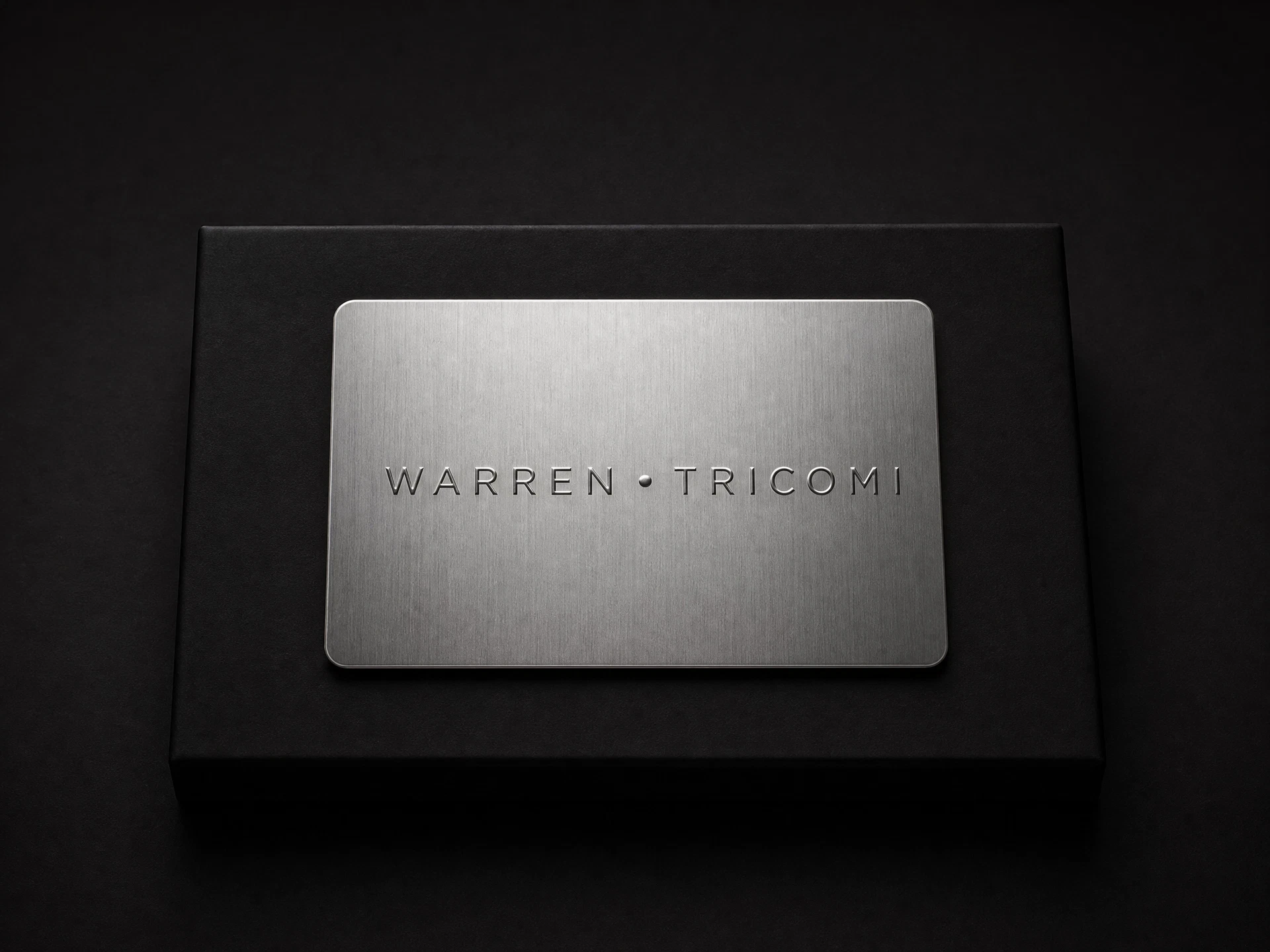 Silver Warren Tricomi gift card on a black presentation field